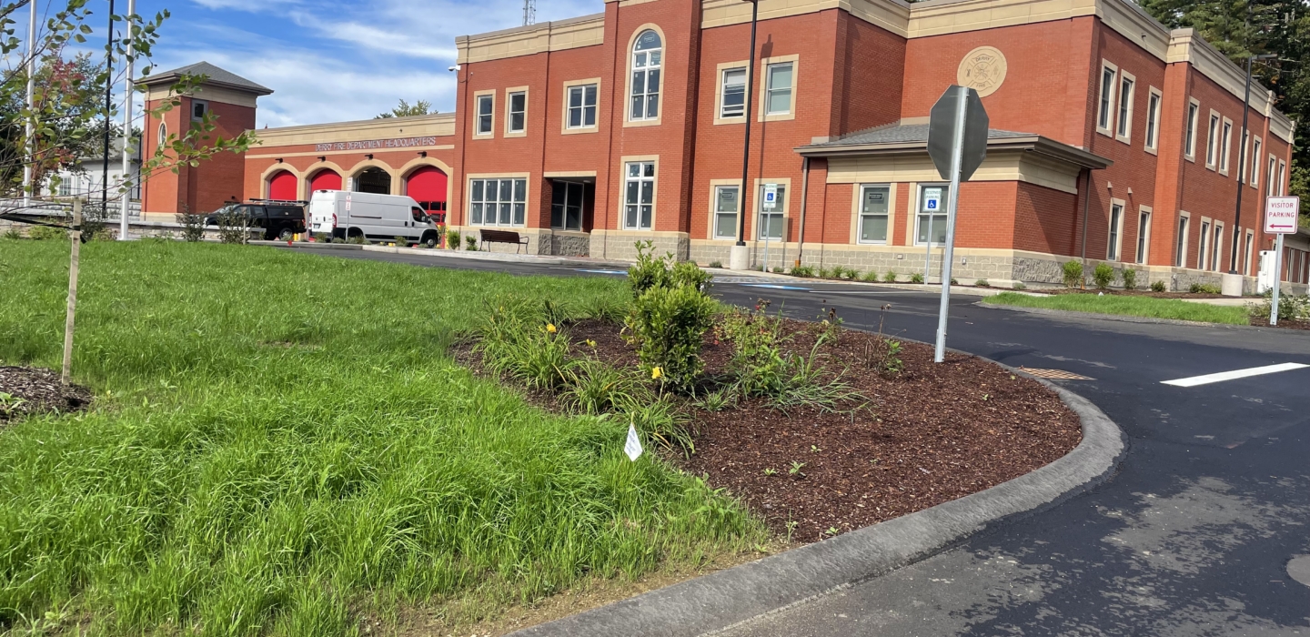 Constructed brick fire station with drive aisle and landscaping.